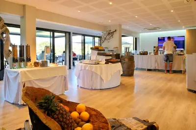 a room with two tables and a room with fruit on the floor at Hotel Bartaccia in Propriano