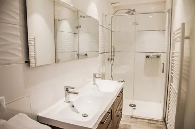 a white bathroom with a sink and a shower at Appartement Gialla in Porto-Vecchio