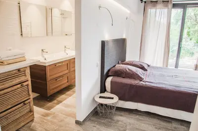a bedroom with a bed and a sink and a mirror at Appartement Gialla in Porto-Vecchio