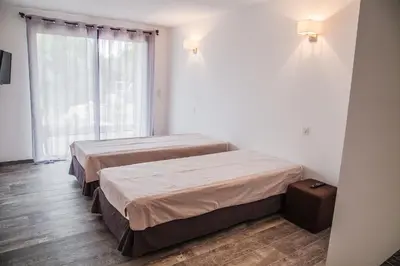 two beds in a room with a window at Appartement Gialla in Porto-Vecchio
