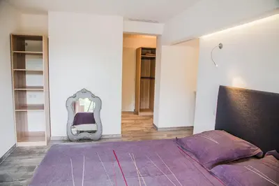 a bedroom with a purple bed and a mirror at Appartement Gialla in Porto-Vecchio