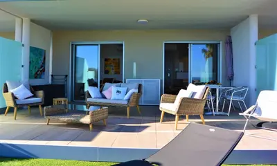 a patio with chairs and a table on a deck at TADO in Kamiesch