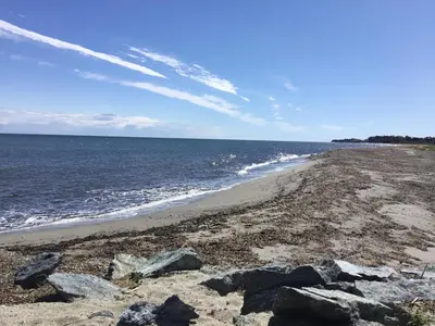 a beach with rocks and the ocean on a sunny day at Studio Marymer in Cervione