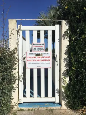 a white gate with a sign on it at Studio Marymer in Cervione