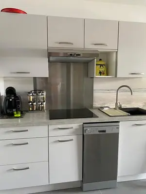 a kitchen with white cabinets and a sink at Studio Marymer in Cervione