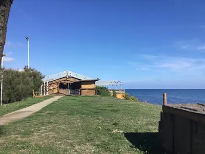 a building on a hill next to the ocean at Studio Marymer in Cervione