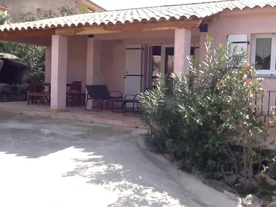 a house with a porch with a table and chairs at Casa Myrta 3 étoiles in Porto-Vecchio