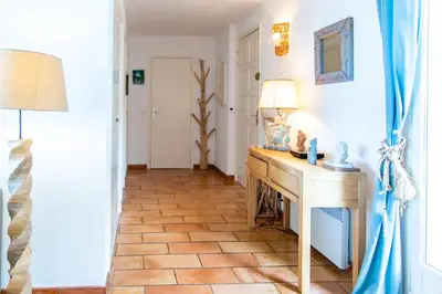 a hallway with a wooden table and a floor at Appartements L'Acacia - plage d'Argent à 300m in Coti-Chiavari