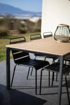 a wooden table and chairs with a lamp on top at T2 au coeur de Porticcio - Vue mer Imprenable ! in Grosseto-Prugna