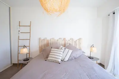 a bed with two lamps and two pillows on it at T2 au coeur de Porticcio - Vue mer Imprenable ! in Grosseto-Prugna