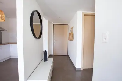 a hallway with a mirror on the wall and a door at T2 au coeur de Porticcio - Vue mer Imprenable ! in Grosseto-Prugna