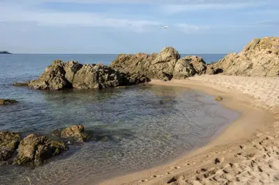 a sandy beach with rocks and the ocean at T2 au coeur de Porticcio - Vue mer Imprenable ! in Grosseto-Prugna
