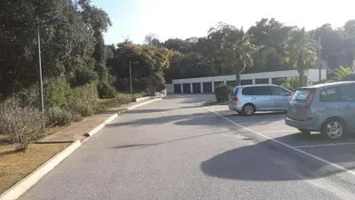 two cars are parked in a parking lot at T2 au coeur de Porticcio - Vue mer Imprenable ! in Grosseto-Prugna