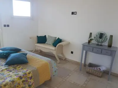a bedroom with a bed and a chair and a table at sci marie dominique in Olmeto