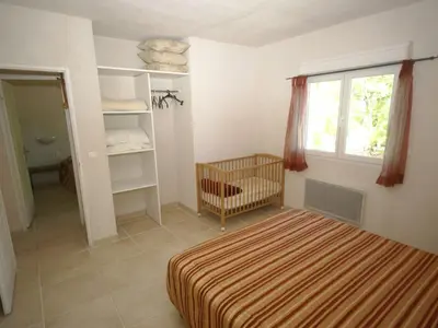 a bedroom with a bed and a window and a crib at Villa in Moriani-Plage with Sea View in San-Nicolao