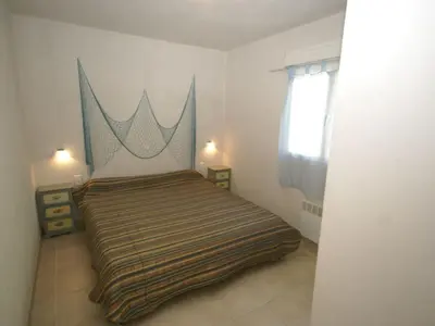 a bedroom with a bed with a striped blanket at Villa in Moriani-Plage with Sea View in San-Nicolao