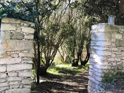 an old stone wall with trees in the background at Résidence hôtelière A TRAMA in Bonifacio