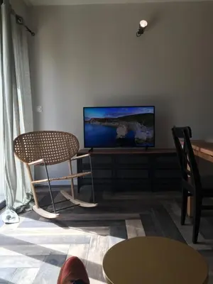 a living room with a tv and two chairs and a table at Maison Corse in Aléria