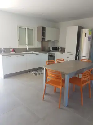 a kitchen with a table and chairs in it at SARL valinco locations in Olmeto