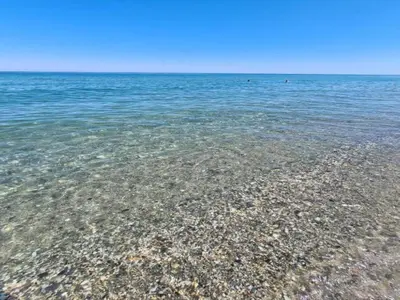 a large body of water with a rocky beach at Riverside Home in Folelli in Penta-di-Casinca
