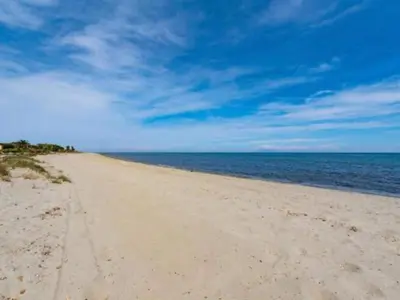 a sandy beach with the ocean in the background at Riverside Home in Folelli in Penta-di-Casinca