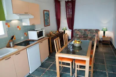 a kitchen and dining room with a table and chairs at Résidence Villa Nova in Tiuccia