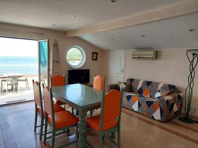 a dining room with a table and chairs and a couch at Résidence Villa Nova in Tiuccia