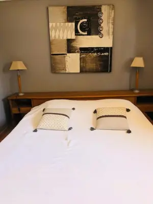 a bedroom with a large white bed with two lamps at Résidence Villa Nova in Tiuccia