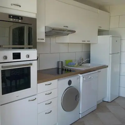 a white kitchen with a sink and a dishwasher at Résidence Villa Nova in Tiuccia
