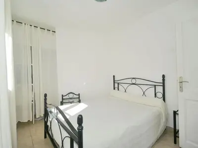 a white bedroom with a black bed and a window at Villa in Moriani-Plage by the Sea in San-Nicolao