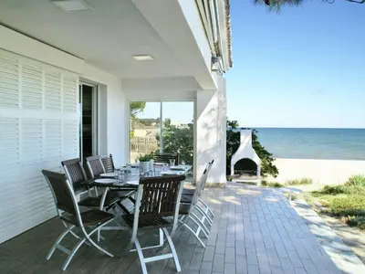 a patio with a table and chairs and the ocean at Villa in Moriani-Plage by the Sea in San-Nicolao