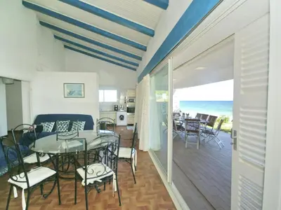 a dining room and living room with a table and chairs at Villa in Moriani-Plage by the Sea in San-Nicolao