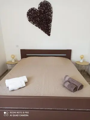 a bed with two towels and a heart on the wall at Sagone in Vico