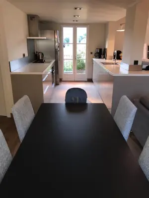 a kitchen with a black table and chairs in a room at Appartement Centre ville in Porto-Vecchio