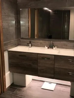 a bathroom with a sink and a large mirror at Appartement Centre ville in Porto-Vecchio
