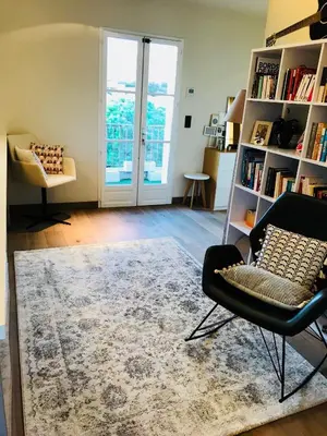 a living room with a chair and a rug at Appartement Centre ville in Porto-Vecchio