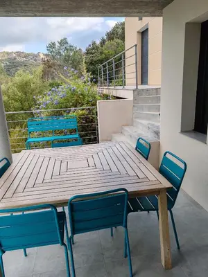 a wooden table and chairs on a balcony at Villa neuve architecte vue mer in Belvédère