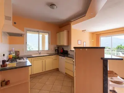 a large kitchen with yellow cabinets and a window at Spacious Villa with Pool in Santʼ Andrea-dʼOrcino