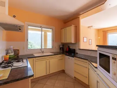 a kitchen with yellow walls and white cabinets at Spacious Villa with Pool in Santʼ Andrea-dʼOrcino
