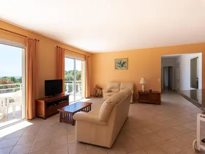 a living room with a couch and a tv at Spacious Villa with Pool in Santʼ Andrea-dʼOrcino
