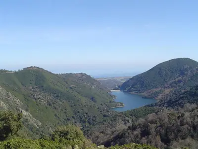 a view of a lake between two hills at Maison de charme Corse sauvage in Pietra-di-Verde