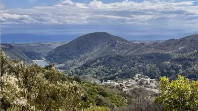 a view of a mountain range with a town in the foreground at Maison de charme Corse sauvage in Pietra-di-Verde