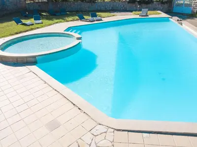 a large blue swimming pool with chairs in it at Résidence de Filitosa - Le Torréen in Sollacaro