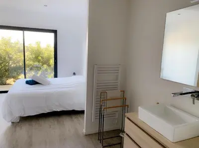 a white bedroom with a bed and a sink at Villas Pure Mare Bonifacio in Bonifacio