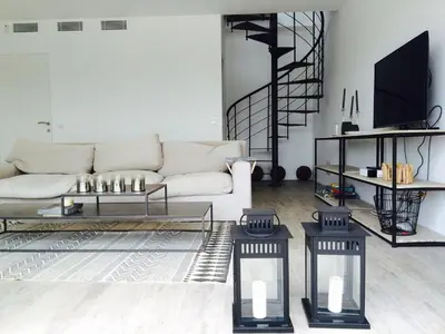 a living room with a white couch and a tv at Villas Pure Mare Bonifacio in Bonifacio