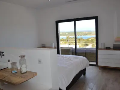 a bedroom with a bed and a large window at Villas Pure Mare Bonifacio in Bonifacio