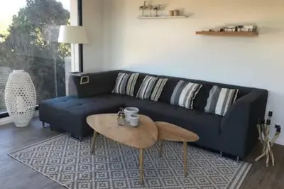 a living room with a blue couch and a coffee table at Villas Pure Mare Bonifacio in Bonifacio