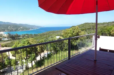 a balcony with an umbrella and a view of the ocean at MORA in Conca