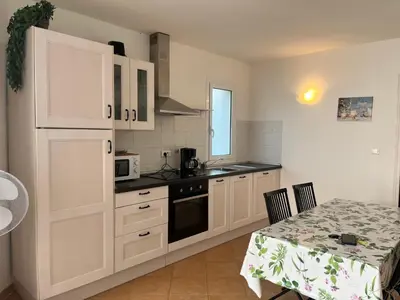 a kitchen with white cabinets and a table and a table and a table at MORA in Conca