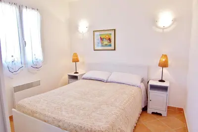 a white bedroom with a bed and two lamps at MORA in Conca